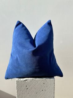 a blue pillow sitting on top of a cement block