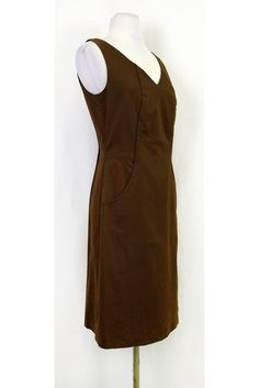 Sophisticated brown dress with a subtle pattern. Perfect for the office, style it with a blazer and pumps. You will be ready to hit the board room in style. Size 2 98% cotton, 2% elastane V-neck Back zipper Sleeveless Large front pockets Patterned fabric Lined Bust 34" Waist 30" Shoulder to hem 38.25" Brown Fitted Knee-length Midi Dress, Brown Cotton Lined Dress, Brown Cotton Midi Dress For Work, Elegant Cotton Business Casual Dress, Elegant Cotton Dress For Business Casual, Brown V-neck Midi Dress For Work, Brown Sheath Midi Dress For Formal Occasions, Formal Brown Sheath Midi Dress, Brown Fitted Cotton Dress