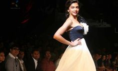 a woman in a white and black dress on the catwalk at a fashion show