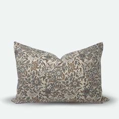 a pillow with a floral pattern on it, sitting on a white surface and facing the camera