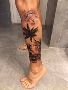 a man's leg with a palm tree and parasail tattoo on it