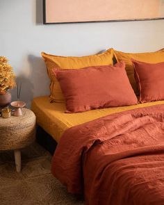 a bed with orange sheets and pillows in a room