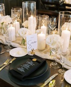 the table is set with candles, plates and napkins for an elegant wedding reception