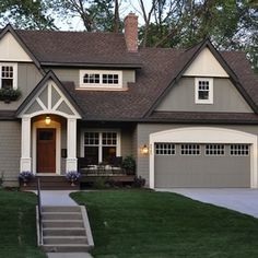 a gray house with white trim and brown roof