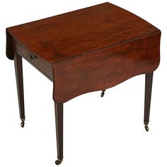 a small wooden table with wheels on it's legs and an open drawer at the top