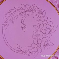 the embroidery pattern is on top of a purple plate with gold trimmings and flowers