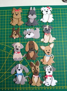 cut out dogs sitting on top of a green cutting board next to scissors and tape