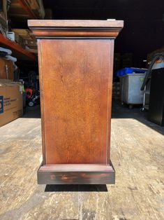 a tall wooden clock sitting on top of a table