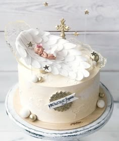 there is a small cake that has angel wings on it and stars around the edges