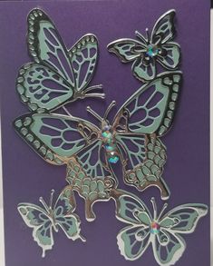 a card with butterflies on it in purple and green colors, one is cut out to look like they are flying