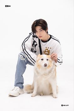 a man kneeling down next to a white and brown dog