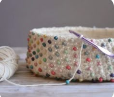 a crochet basket with yarn and scissors on the table