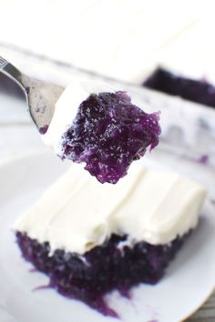 a piece of blueberry cheesecake on a white plate with a fork in it