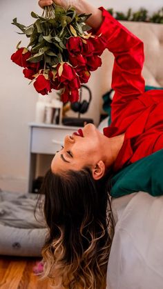 a woman laying on the floor with flowers in her hands