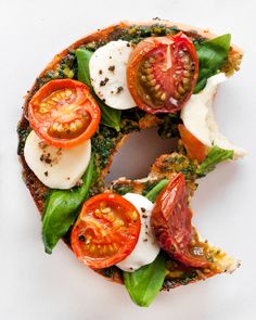 an open face sandwich with tomatoes, mozzarella and spinach leaves on it