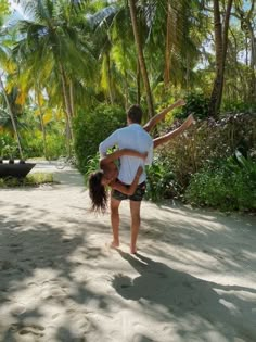 a man and woman are doing yoga on the beach in front of some palm trees