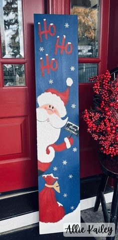 a christmas door hanger with santa clause painted on it