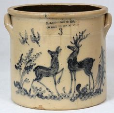 an old ceramic pot with deer and flowers on it