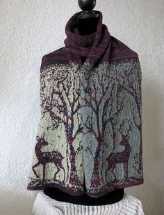 a knitted shawl with deer and trees on it