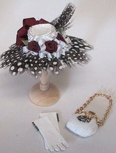 an arrangement of flowers and accessories on a white tablecloth with a pair of gloves next to it