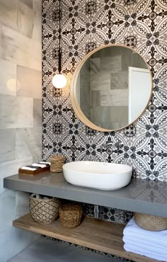 a bathroom with a sink, mirror and towel on the shelf in front of it