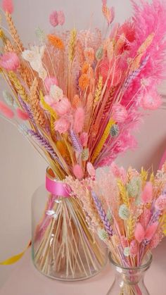 two vases filled with pink and yellow flowers