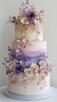 a multi - tiered cake with flowers on the top is decorated in pastel colors