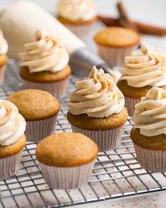 cupcakes with white frosting sitting on a cooling rack