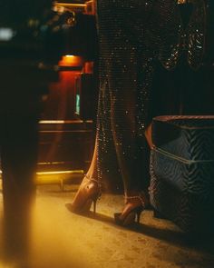 a woman in high heels standing next to a table