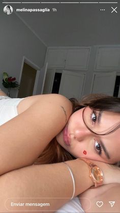 a beautiful young woman laying on top of a bed