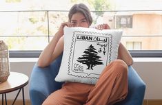 a woman sitting in a chair holding a pillow with a stamp on it that reads library club