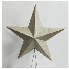 a silver star hanging on a white wall