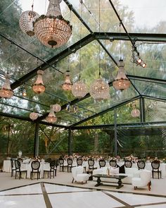 an indoor dining area with chandeliers hanging from the ceiling