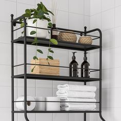 a bathroom shelf with towels, toiletries and plants