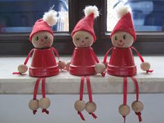 three little red dolls sitting on top of a window sill next to each other