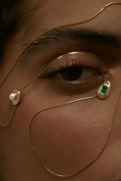 a close up of a person with jewelry on their eyes and eyeliners in the shape of rings