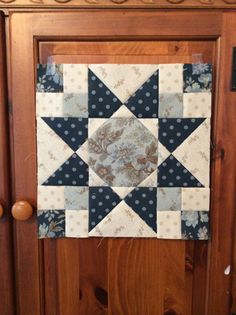 a close up of a wooden door with a patchwork quilt on it