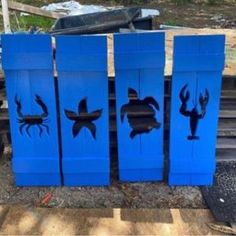 four blue boxes with sea animals painted on them in the shape of lobsters and crabs