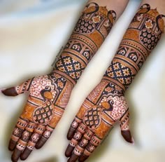 two hands with henna designs on them, one is showing the intricate design and the other has an elaborate pattern