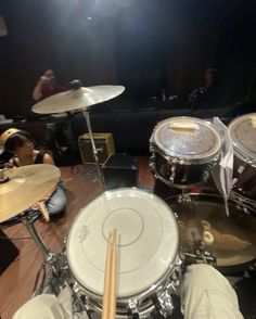 drummers are playing drums in a recording studio