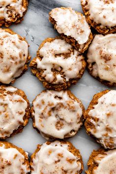 carrot cookies with cream cheese frosting and cinnamon sprinkles on a marble surface