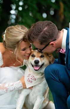 a bride and groom pose with their dog