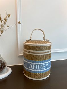 a basket sitting on top of a table next to a vase