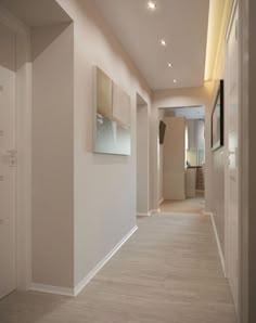 an empty hallway with white walls and wood floors