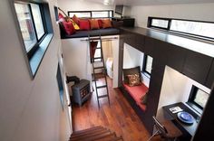 the interior of a tiny house with stairs leading up to it's loft bed