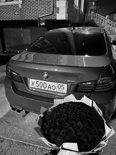 a car parked next to a bunch of roses