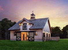 a barn with an open front door at sunset