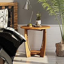 a bedroom with a bed, table and plants in it on the floor next to a chair