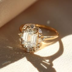 an engagement ring with a large diamond surrounded by smaller diamonds on the side and in the center