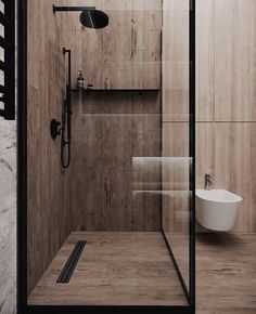 a bathroom with wooden walls and flooring is shown in this image, it has a shower